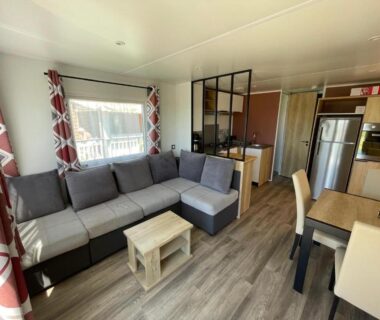 Salon avec canapé d'angle et kitchenette dans le mobilhome Mobilhome-vue lac Lac des Rêves
