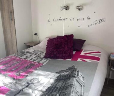 Dans la chambre lit double avec coussins et déco murale dans le mobilhome Sandra