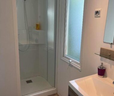 Salle de bain avec cabine de douche et lavabo dans le mobilhome Sandra