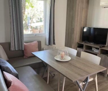 Séjour avec banquette table et télévision dans le mobilhome Sandra