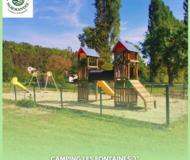 Aire de jeux sur gazon avec toboggans et balançoires au Camping Les Fontaines