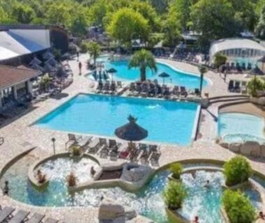 Piscine extérieure avec plusieurs bassins et palmiers au Mobilhomme Privilège