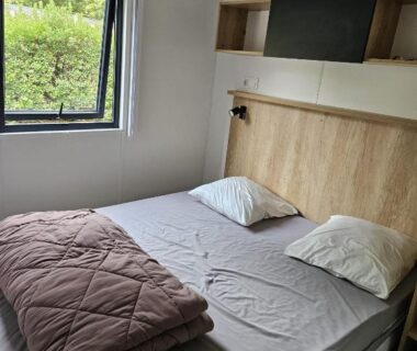 Chambre avec lit double et étagères dans le Mobilhomme Privilège