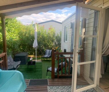 Terrasse couverte avec salon de jardin et parasol du Mobilhomme camping