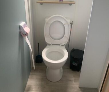 Toilettes intérieures avec porte-papier et brosse dans le mobilhome Mobilhomme camping
