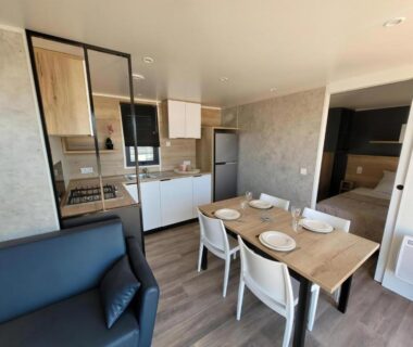 Séjour avec coin cuisine et table dans le Modèle d'exception 3 ch 2 sdb 43m2 proche parc aquatique
