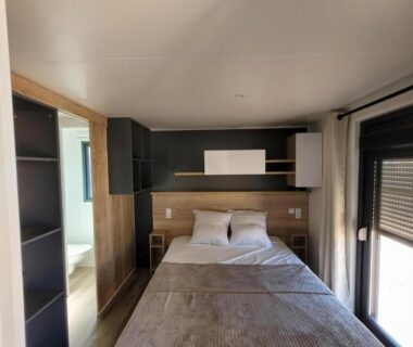 Chambre avec lit double et rangements dans le Modèle d'exception 3 ch 2 sdb 43m2 proche parc aquatique