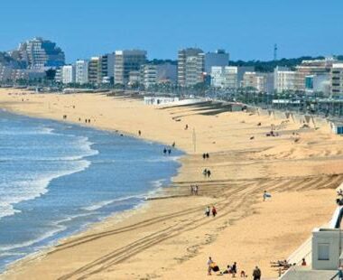 Plage de sable avec promenade et immeubles en bord de mer au camping Mon Coin de Vendée