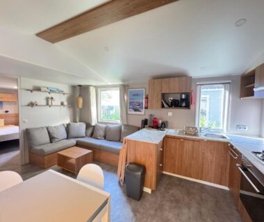 Intérieur salon avec cuisine et coin repas dans le mobil home Mon Ptit coin au ferret