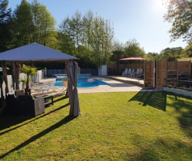 Piscine extérieure et transats sous pergola au Moulin Du Pommier Glamping & Camping