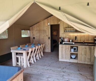 Intérieur de tente avec coin repas et kitchenette du Moulin Du Pommier Glamping et Camping