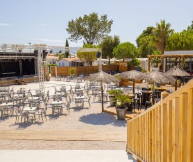 Terrasse extérieure avec tables et parasols au NATITOLOCATION Mobile Home Camping 4etoiles Saint Cyprien