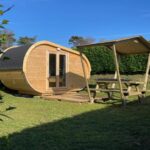 Jardin avec abri tonneau et table de pique-nique au NUIT INSOLITE – Côte de granit rose – Camping Armor Loisirs