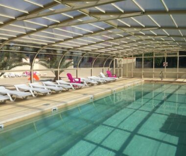 Piscine couverte avec transats au Camping Armor Loisirs