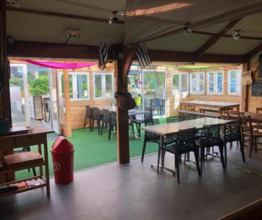 Salle intérieure avec tables et chaises du Camping Armor Loisirs