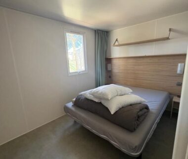 Chambre avec lit et fenêtre au camping Nadege