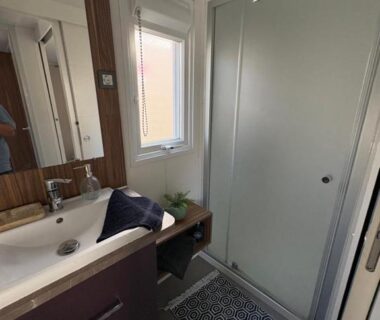 Salle de bain avec douche lavabo et fenêtre au camping Nadege