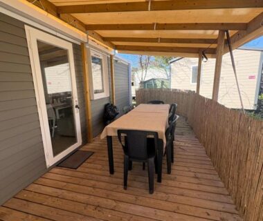 Terrasse en bois couverte avec table et chaises au mobil-home Nadege