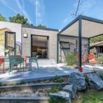 Terrasse avec pergola et chaises longues au camping Le Petit Port