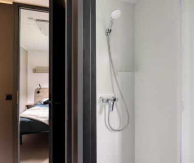 Cabine de douche et ouverture vers la chambre dans l'hébergement du Nantes Camping Le Petit Port