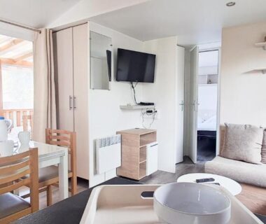 Intérieur du mobil-home avec canapé et coin repas du Naphtase MH01S Le Refuge des Pins