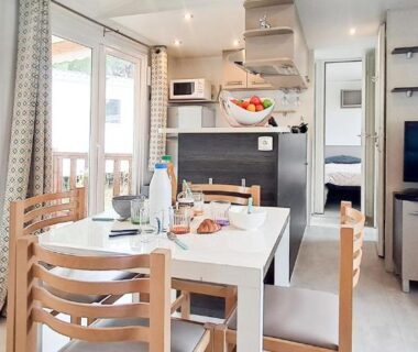 Intérieur avec coin repas et cuisine ouverte dans le mobil home Naphtase MH334S Pins Calmes