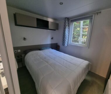 Intérieur chambre avec lit double et fenêtre dans le mobil-home Naphtase MH487S Pause Privilège