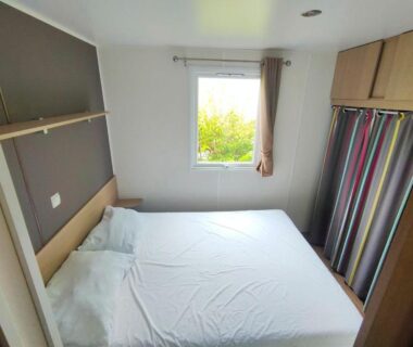 Chambre avec lit double et fenêtre dans le camping Nat & Mayou