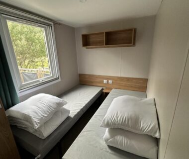 Chambre avec deux lits et fenêtre au Natuara L'écrin du Ferret