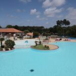 Piscine extérieure avec îlots et transats au Natuara L'horizon du lac