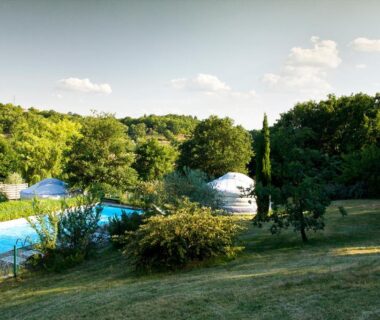 Piscine extérieure et yourtes au milieu des arbres au Natura Lodge