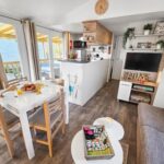 Séjour avec coin repas kitchenette et terrasse vitrée au camping Nature & Sérénité