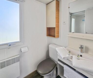 Salle de bains avec toilettes lavabo et fenêtre dans le camping Nature et Sérénité
