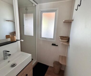 Salle de bain compacte avec lavabo miroir et cabine de douche dans l'hébergement Notre bulle du ferret