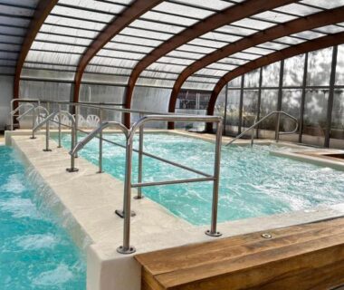 Piscine couverte avec bains à remous et banc en bois dans le camping Notre bulle du ferret