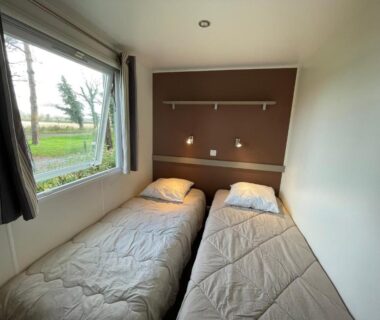 Chambre avec deux lits simples et fenêtre sur jardin au Nouveau Vacance nature au calme