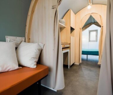 Intérieur de cabine en bois avec banquette et lit de l'O2 Camping