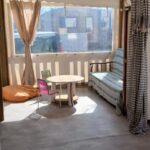 Véranda couverte avec banquette et table au O255 L'Océa