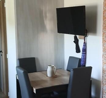Coin repas avec table et télévision dans l'hébergement O255 L'Océa