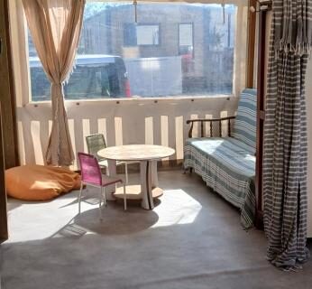 Véranda couverte avec banquette et table au O255 L'Océa