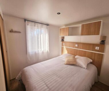 Chambre double avec lit fenêtre et rangement au camping O'ContisParadise