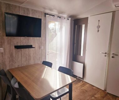 Séjour avec table chaises et télévision dans l'hébergement O’ContisParadise