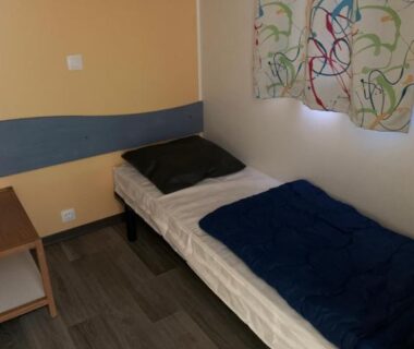 Chambre avec lit simple bureau et rideau dans l'hébergement OPHEA 2 Personnes