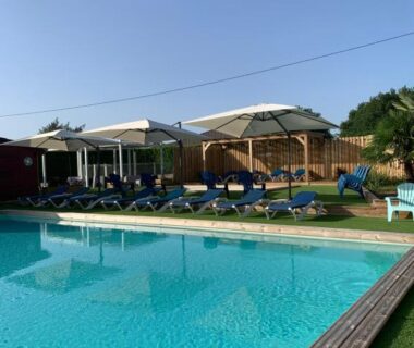 Piscine extérieure avec transats et parasols au camping OPHEA 2 Personnes