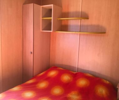 Chambre de mobil-home avec lit et rangement dans l'Oasis village