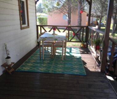 Terrasse en bois avec table et chaises au camping Oasis village