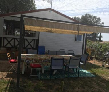 Terrasse ombragée avec table et chaises au mobil-home Oasis village
