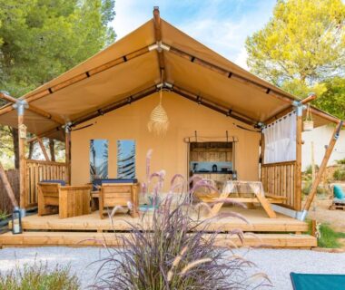 Terrasse en bois et tente glamping avec table de pique-nique au Medrose Camping Ardèche