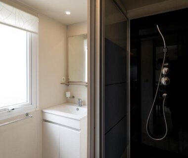 Salle de bain avec douche et lavabo dans l'Ohana Cottage