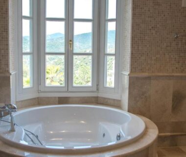 Salle de bain avec baignoire balnéo devant fenêtre avec vue à OliviersMaison H1